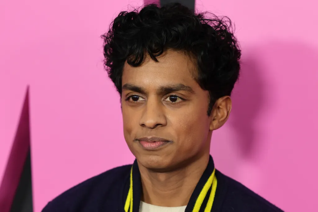 Rajiv Surendra against a pink background at the New York City Mean Girls premiere.
