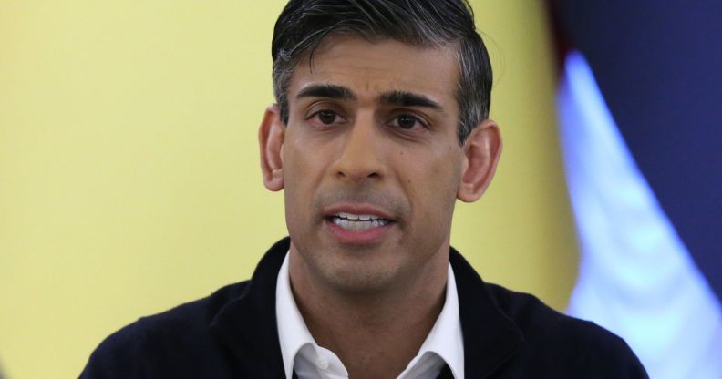 Rishi Sunak, speaking infront of a yellow flag during a news conference.