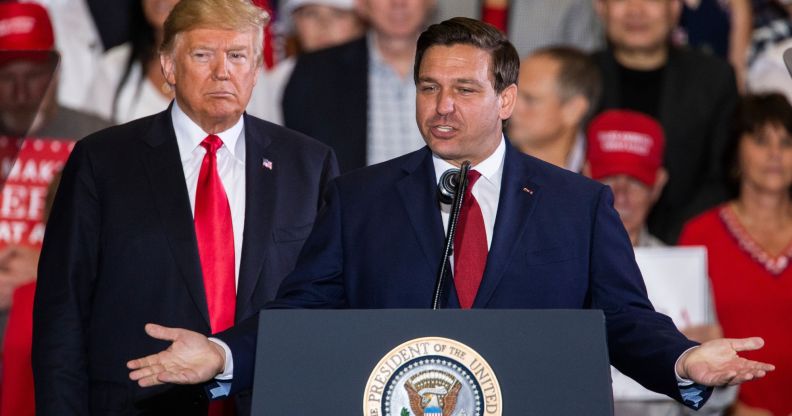 Ron DeSantis stands at a podium next to former president Donald Trump
