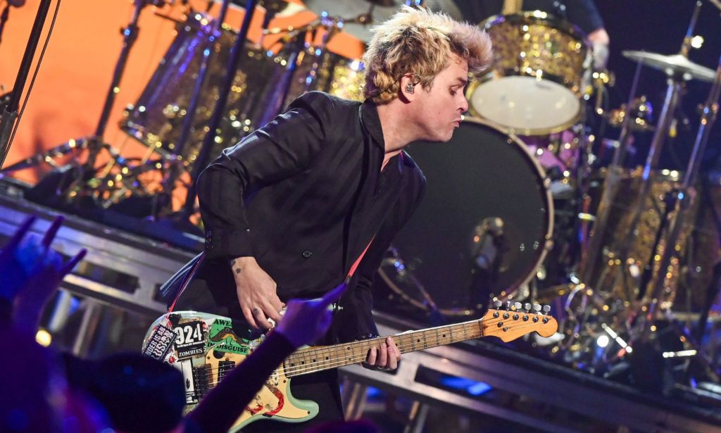 Green Day frontman Billie Joe Armstrong plays the guitar as the band performs onstage during a New Year's Eve concert. During the performance, the band changed the lyrics of their hit song "American Idiot" to slam Donald Trump and his MAGA supporters