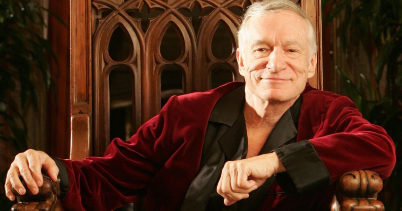 Hugh Hefner in a red and black robe.