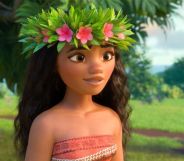 A still of the Disney character Moana wearing a red and white patterned top with a floral headband