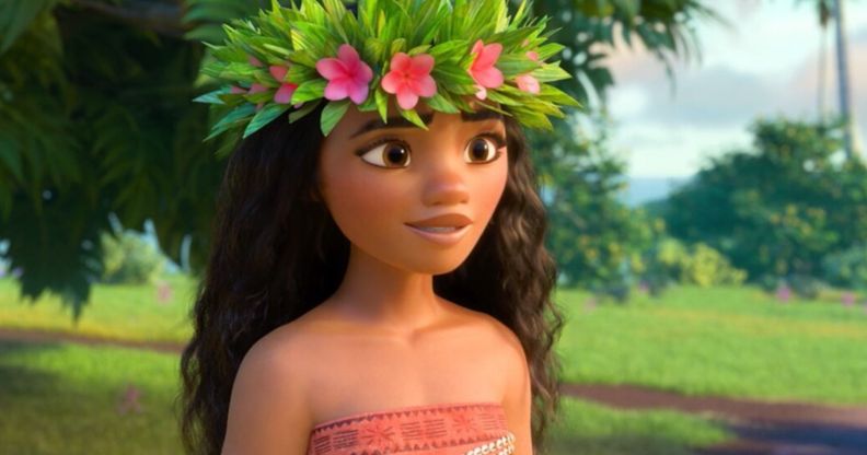 A still of the Disney character Moana wearing a red and white patterned top with a floral headband