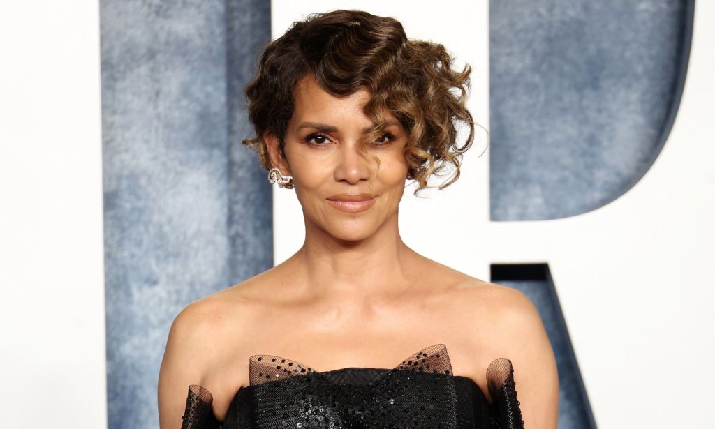 Halle Berry, a non-LGBTQ+ actor who once considered playing a queer, trans role, looks towards the camera while wearing a black dress made of tulle 