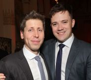 OpenAI CEO Sam Altman and husband Oliver Mulherin wear dark suits as they hug each other and smile for a photo