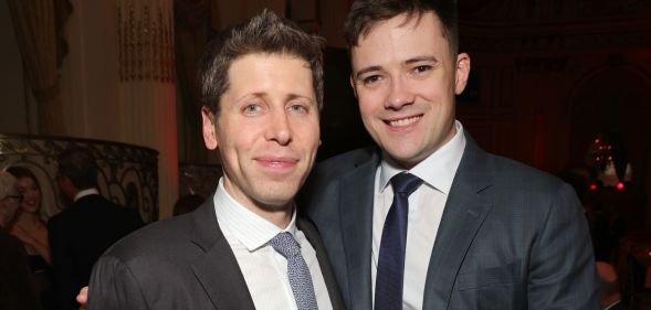 OpenAI CEO Sam Altman and husband Oliver Mulherin wear dark suits as they hug each other and smile for a photo