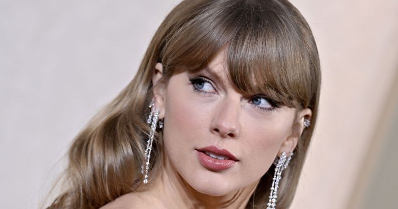 Taylor Swift looks over her shoulder as she wears a green dress and silver dangling earrings at an event
