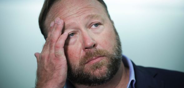 A man rests his forehead on his palm.