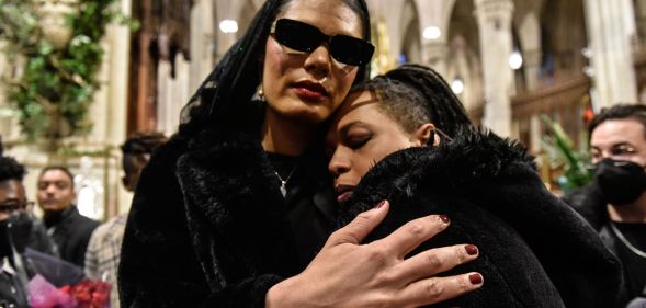 Attendees of Cecilia Gentili's funeral embrace inside St Patrick's Cathedral.