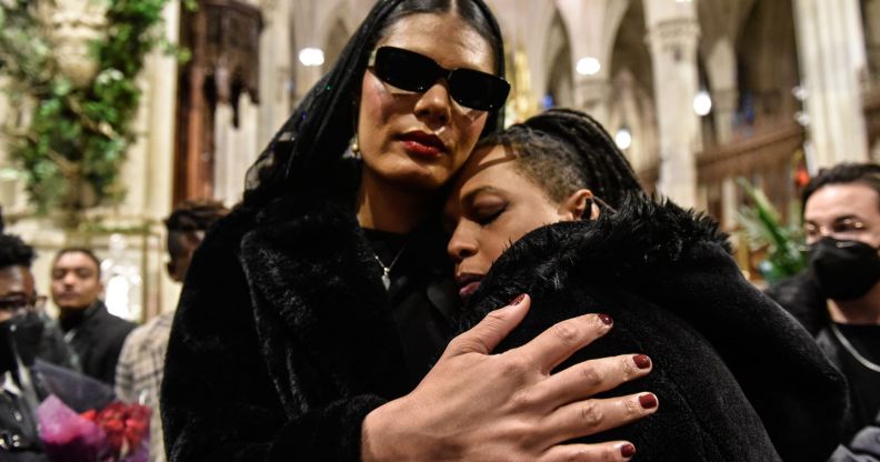 Attendees of Cecilia Gentili's funeral embrace inside St Patrick's Cathedral.