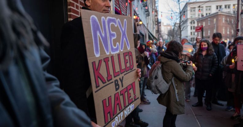 People gather outside the Stonewall Inn for a memorial and vigil for the Oklahoma teenager who died following a fight in a high school bathroom on February 26, 2024 in New York City. Nex Benedict, a 16-year-old who identified as nonbinary and used they/them pronouns, died a day after the altercation in the school bathroom. One protester is holding a sign that says 'Nex, killed by hate'