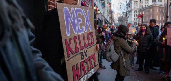 People gather outside the Stonewall Inn for a memorial and vigil for the Oklahoma teenager who died following a fight in a high school bathroom on February 26, 2024 in New York City. Nex Benedict, a 16-year-old who identified as nonbinary and used they/them pronouns, died a day after the altercation in the school bathroom. One protester is holding a sign that says 'Nex, killed by hate'