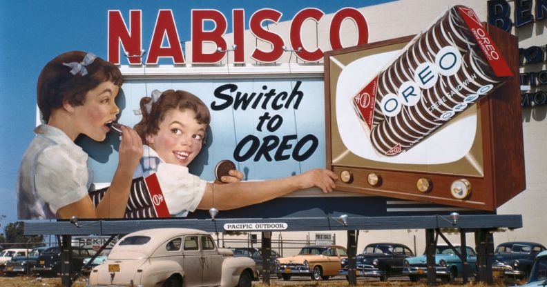 Image shows a vintage billboard with two children on it, the billboard says 'Nabisco: Switch to Oreo'