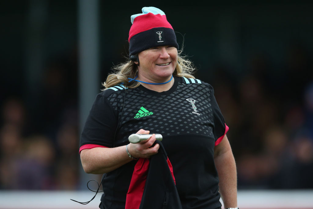 Photo showing Karen Findlay at a rugby match acting as coach, she's wearing a dark coloured t-shirt and wearing a red and black bobble hat. 