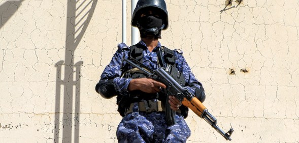 A member of security forces loyal to Yemen's Houthi movement stands guard as armed supporters of the Huthis attend a pro-Palestinian rally in the Huthi-held capital Sanaa on February 7, 2024 amid the ongoing conflict in the Gaza Strip between Israel and the Palestinian militant group Hamas. (Photo by MOHAMMED HUWAIS / AFP)