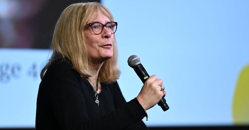 Lucy Sante speaks at a panel event, with a microphone in hand