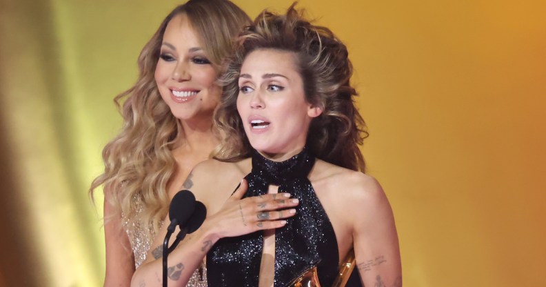LOS ANGELES, CALIFORNIA - FEBRUARY 04: (FOR EDITORIAL USE ONLY) Miley Cyrus (R) accepts the "Best Pop Solo Performance" Award for "Flowers" from Mariah Carey (L) onstage during the 66th GRAMMY Awards at Crypto.com Arena on February 04, 2024 in Los Angeles, California. (Photo by Amy Sussman/Getty Images)