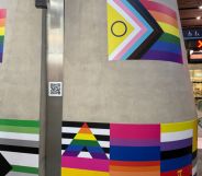 A pillar with stickers of LGBTQ+ flags across it at London Bridge station marking LGBT+ History Month