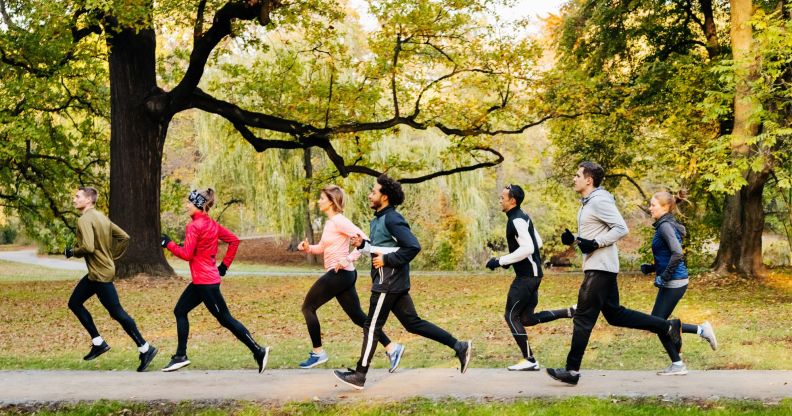 Six people of different genders and ages and race running in the woods, as Parkrun is a community event allowing for trans inclusion