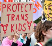 Protester holds a sign reading "protect trans kids"