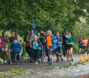 Group of people run through a green area to illustrate Parkrun event