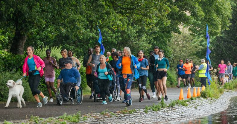 Group of people run through a green area to illustrate Parkrun event