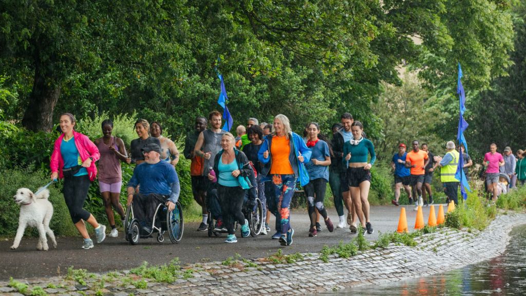 Group of people run through a green area to illustrate Parkrun event