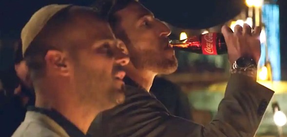 Photo shows two gay dads watching their daughter roller skate.