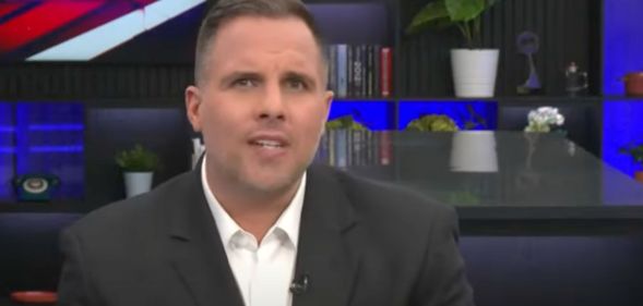 Journalist Dan Wootton wears a suit and tie as he presents a show on GB News