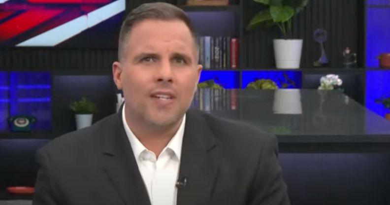 Journalist Dan Wootton wears a suit and tie as he presents a show on GB News