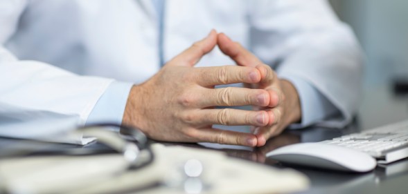 Doctor sitting at desk and his files