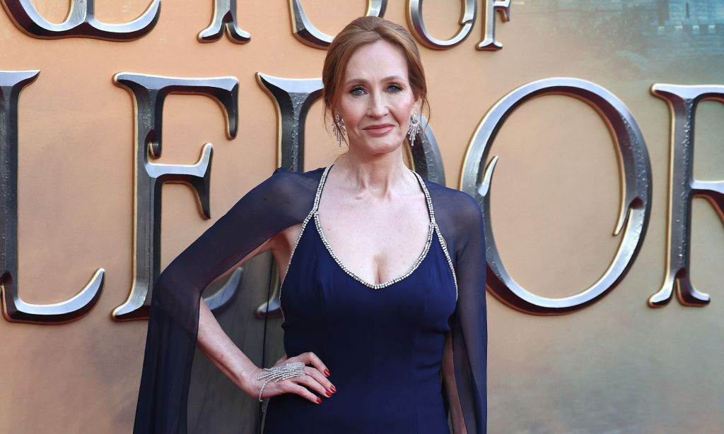 JK Rowling wears a dark blue dress with a matching cap as she appears at a movie premiere