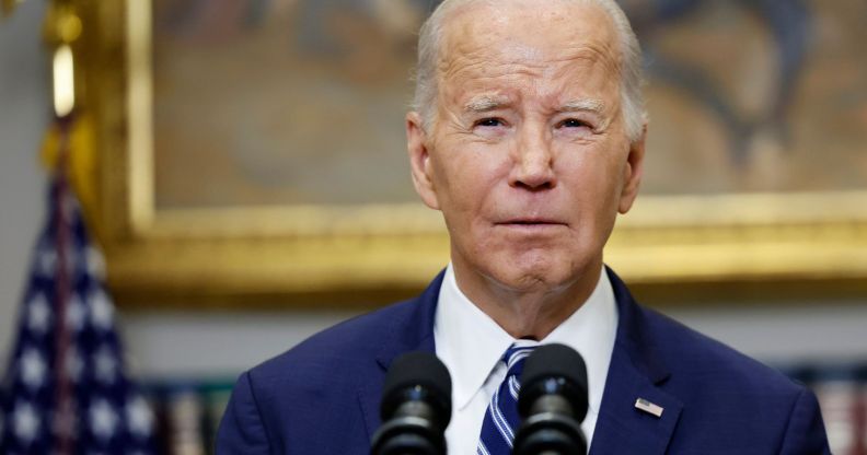 President Joe Biden wears a suit and tie as he stands in front of microphones at the White House