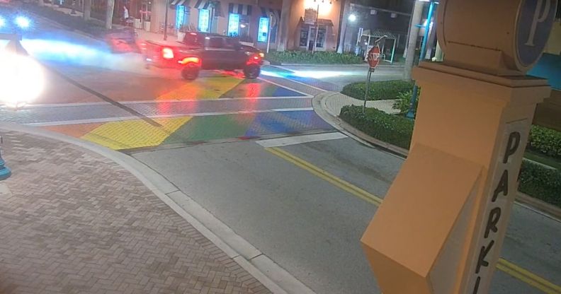 A dark coloured truck burns tire marks into a rainbow coloured crosswalk memorial dedicated to the victims and survivors of the Pulse nightclub shooting in Florida