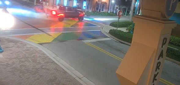 A dark coloured truck burns tire marks into a rainbow coloured crosswalk memorial dedicated to the victims and survivors of the Pulse nightclub shooting in Florida