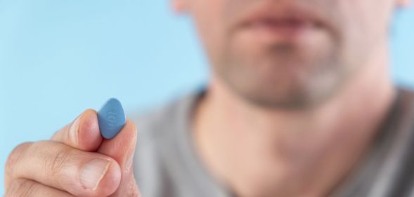 man holding a blue erectile dysfuncrtion viagra pill
