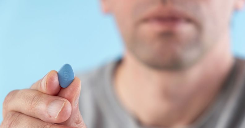 man holding a blue erectile dysfuncrtion viagra pill