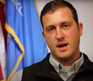 Oklahoma senator Tom Woods (R) wears a grey shirt and black vest as he speaks to camera. The Republican lawmaker described LGBTQ+ people as "filth" after being questioned about anti-LGBTQ+ laws and the death of non-binary teen Nex Benedict