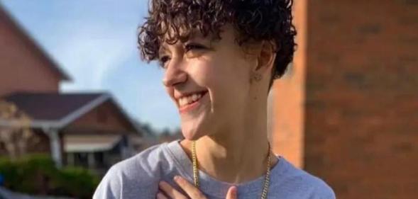 Photo shows Alex Franco smiling and looking to his right with his hand on his chest