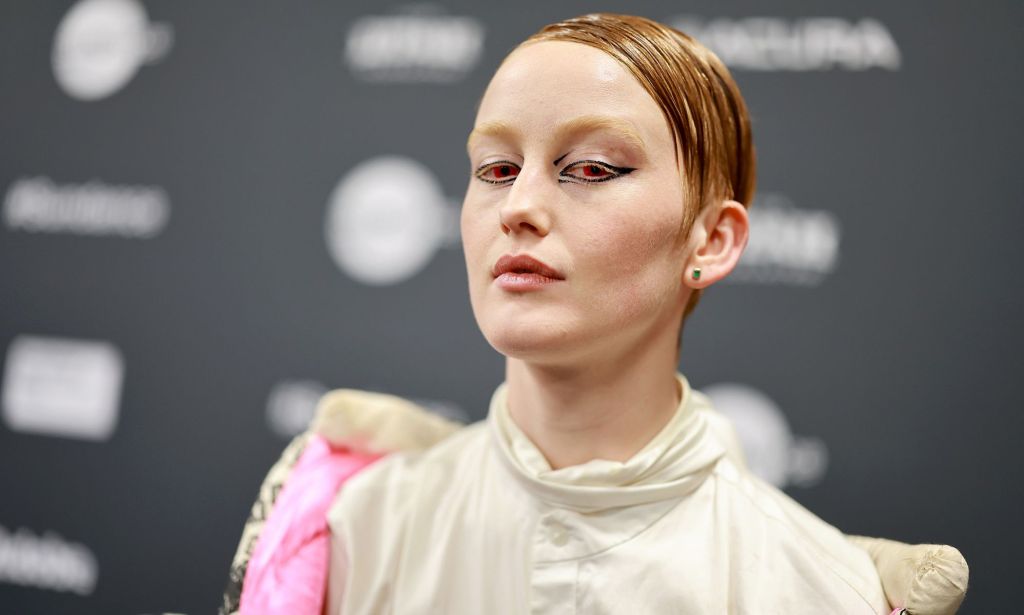 Bobbi Salvör Menuez in a white top with ginger hair slicked to the side.