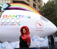 SYDNEY, AUSTRALIA - MARCH 02: A Parade goer stands in front of the QANTAS float ahead of the Sydney Gay & Lesbian Mardi Gras Parade on March 02, 2024 in Sydney, Australia. The Sydney Gay and Lesbian Mardi Gras parade began in 1978 as a march to commemorate the 1969 Stonewall Riots in New York and has been held every year since to promote awareness of gay, lesbian, bisexual and transgender issues. (Photo by Jenny Evans/Getty Images)