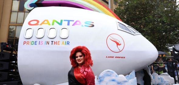 SYDNEY, AUSTRALIA - MARCH 02: A Parade goer stands in front of the QANTAS float ahead of the Sydney Gay & Lesbian Mardi Gras Parade on March 02, 2024 in Sydney, Australia. The Sydney Gay and Lesbian Mardi Gras parade began in 1978 as a march to commemorate the 1969 Stonewall Riots in New York and has been held every year since to promote awareness of gay, lesbian, bisexual and transgender issues. (Photo by Jenny Evans/Getty Images)