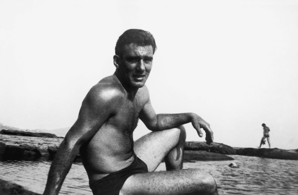 London gangster Reggie Kray (1933 - 2000) relaxing shirless by the sea during a holiday, circa 1965.  