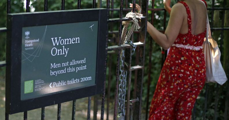 A woman walks through the gate of a women-only pond.