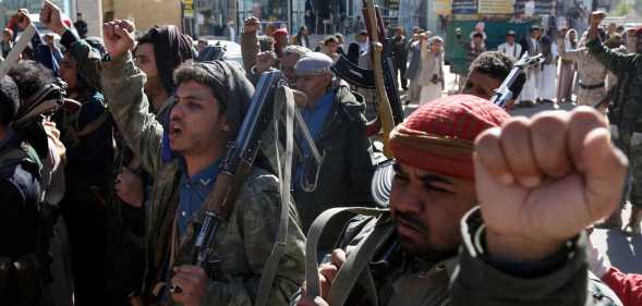 SANA'A, YEMEN - JANUARY 11: Yemeni protestors loyal to the Houthi movement lift their rifles as they participate in a protest held against Israel's ongoing war on Gaza and threats of the U.S. and UK amid U.S. Secretary of State Antony Blinken's warning of a military response to rebel attacks in the Red Sea on January 11, 2024 in Sanaa, Yemen. (Photo by Mohammed Hamoud/Getty Images)