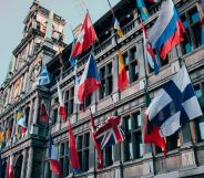 This is an image of a European building adorned with many flags of the world.