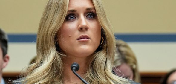 Riley Gaines sitting in a legislative table.