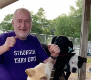 John Walter Lay who was fatally shot at West Dog Park in Tampa, he is wearing a purple shirt that reads 'stronger than dirt' and is surrounded by three dogs.