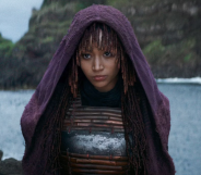 Amandla Stenberg in The Acolyte, standing on the seashore wearing a purple hooded robe