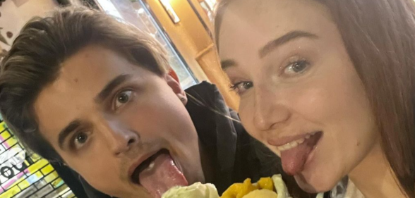 Nikita Kuzmin with current girlfriend Lauren Jaine, they're both posing while eating ice cream
